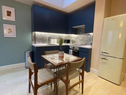 a kitchen with a table and chairs and a refrigerator at 1 Bed Garden Flat Finsbury Park in London