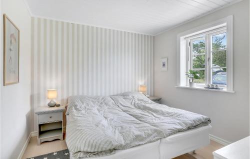 ein weißes Schlafzimmer mit einem Bett und einem Fenster in der Unterkunft Cozy Home In Aakirkeby With Kitchen in Vester Sømarken