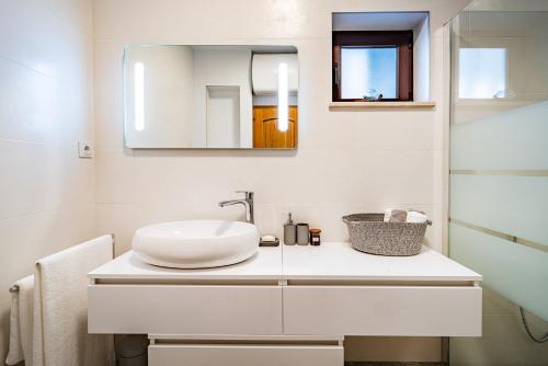 a white bathroom with a sink and a mirror at Villa Kadena - Luxury Seaside Villa with Private Heated Pool in Selca