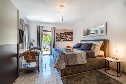 a bedroom with a bed and a desk and a window at Villa Kadena - Luxury Seaside Villa with Private Heated Pool in Selca
