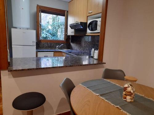 eine Küche mit einem Holztisch sowie einem Tisch und Stühlen in der Unterkunft Apartamento rural Muga in Sant Llorenç de la Muga