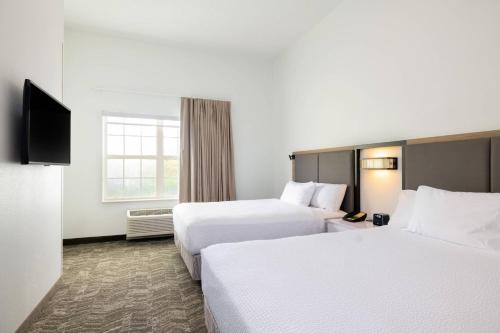 a hotel room with two beds and a television at SpringHill Suites by Marriott Williamsburg in Williamsburg