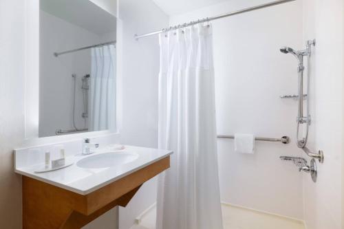威廉斯堡的住宿－威廉斯堡萬豪春季山丘套房酒店，白色的浴室设有水槽和淋浴。