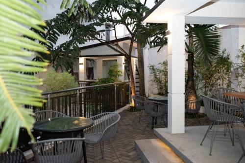 an outdoor patio with tables and chairs and trees at Hotel Areca in Legazpi