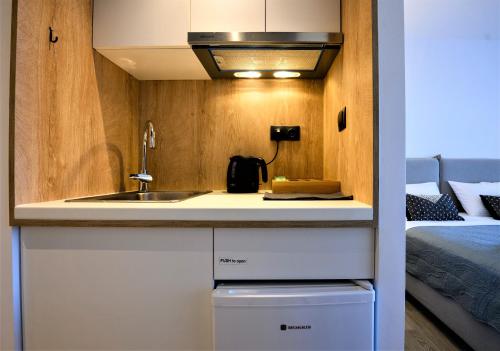 a small kitchen with a sink and a bed at CUBES ON THE BEACH Athens Airport in Artemida
