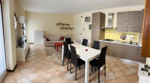 a kitchen and living room with a white table and chairs at Appartamento centro storico Conegliano in Conegliano