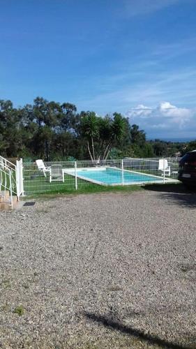une clôture avec une piscine dans un parking dans l'établissement bas de villa de 90m² entre mer (2km) et montagne, à Talasani