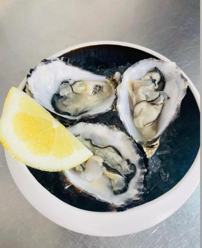 a bowl of oysters with a slice of lemon at Il Cinghialetto in Fonni