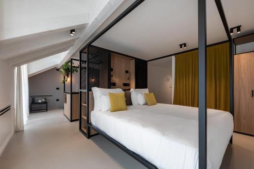 una camera da letto con un grande letto bianco con cuscini gialli di Palais Hörtenberg a Bolzano