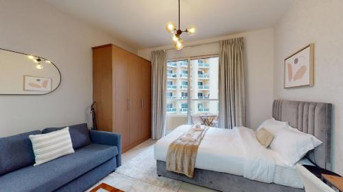 1 dormitorio con 1 cama y 1 sofá azul en LS10-Well Designed Studio In Lake Side Tower A en Dubái