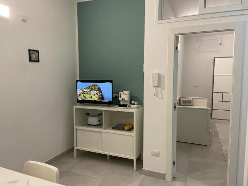 una stanza con una televisione su un supporto con una porta di Approdo Felice a Formia