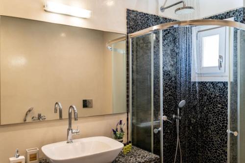 a bathroom with a sink and a shower at In the heart of Fira & free pool - Nychteri suite in Fira