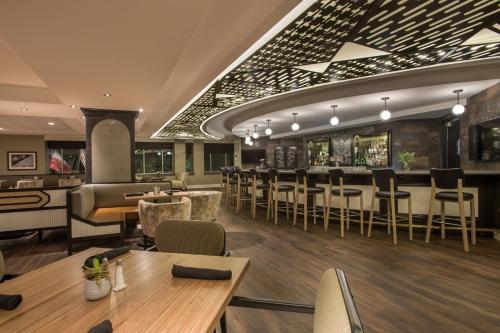 a restaurant with tables and chairs and a bar at Magnolia Hotel Houston, a Tribute Portfolio Hotel in Houston