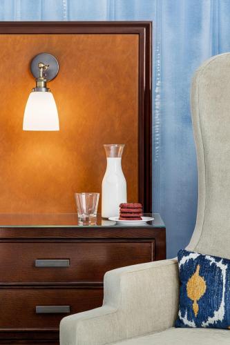 a chair and a vase on a table with a lamp at Magnolia Hotel Houston, a Tribute Portfolio Hotel in Houston