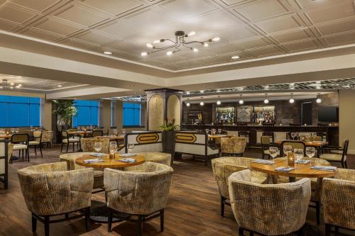 a restaurant with tables and chairs and a bar at Magnolia Hotel Houston, a Tribute Portfolio Hotel in Houston