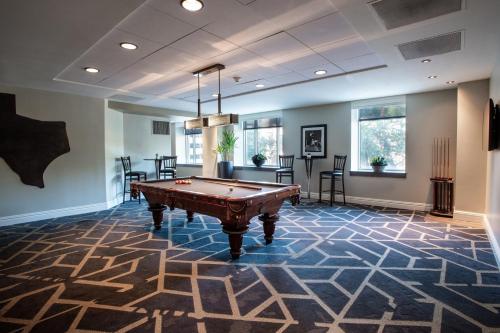 a room with a pool table in the middle at Magnolia Hotel Houston, a Tribute Portfolio Hotel in Houston