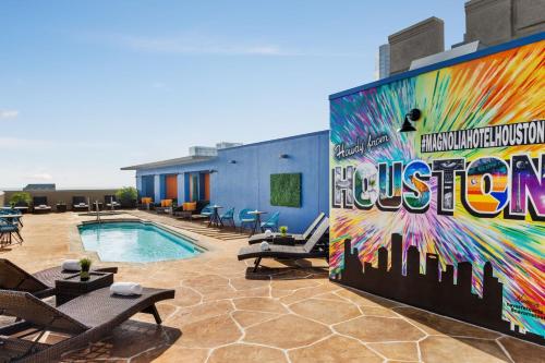 a mural on the side of a building with a pool at Magnolia Hotel Houston, a Tribute Portfolio Hotel in Houston