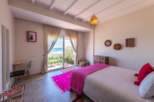 - une chambre avec un lit et une vue sur l'océan dans l'établissement Kite House Dakhla, à Dakhla