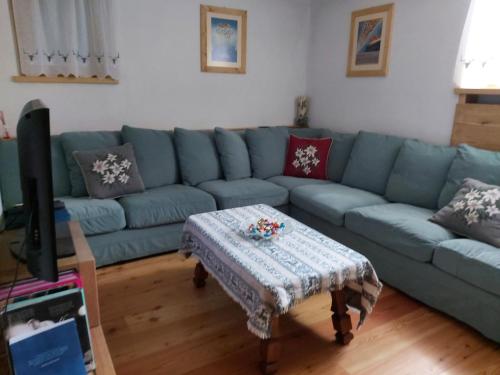 uma sala de estar com um sofá azul e uma mesa de centro em APPARTAMENTO CORTINA 1956 em Cortina dʼAmpezzo