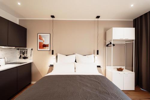 a bedroom with a bed and a kitchen at NUVA Apartments in Cologne