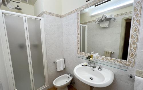 a bathroom with a sink and a toilet and a mirror at B&B Piccolo Hotel in Cortona
