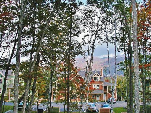 a group of trees in front of a house at Tremblant Les Eaux by Rendez-Vous Mont-Tremblant in Mont-Tremblant