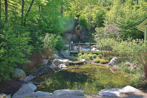 a bridge over a pond in a garden at Tremblant Les Eaux by Rendez-Vous Mont-Tremblant in Mont-Tremblant