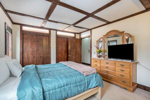 a bedroom with a bed and a dresser with a television at The Sugar Maple Home in South Haven