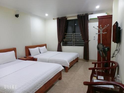 Una habitación de hotel con dos camas y un televisor. en Guesthouse Anh Khang, en Ha Long