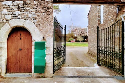- une entrée à un vieux bâtiment avec une porte en bois dans l'établissement Manoir de L'Aisnerie, à Saint-Herblain