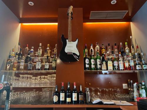 a bar with a guitar on a wall with bottles of alcohol at Charming Blue in Vila do Porto