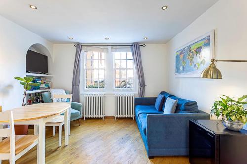 a living room with a blue couch and a table at Gorgeous Angel Flat in London