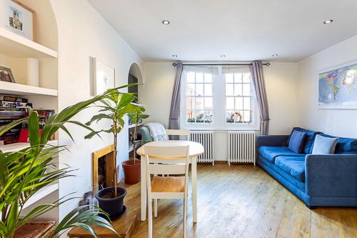a living room with a blue couch and a table at Gorgeous Angel Flat in London