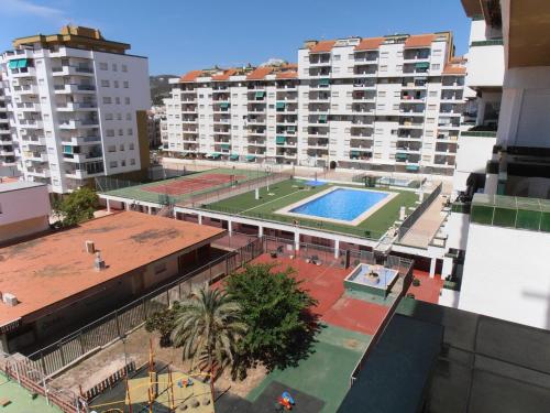 an apartment complex with a pool in the middle of a city at Apartamentos Peñíscola Playa in Peniscola