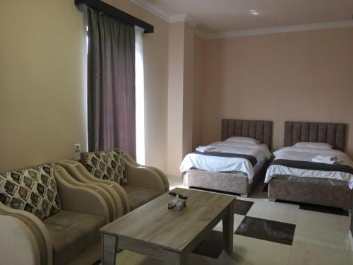 a living room with two beds and a couch and a table at RP HOTEL (NEW) in Yerevan