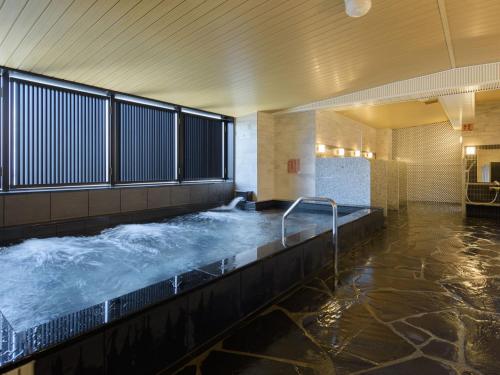 - une grande baignoire avec de l'eau dans un bâtiment dans l'établissement APA Hotel Shinjuku-Kabukicho Tower, à Tokyo