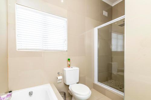 a white bathroom with a toilet and a shower at Modern Executive Unit in East London