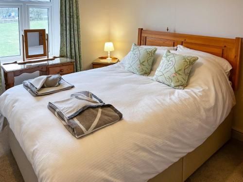 uma cama com duas toalhas e um espelho em Lindum Cottage em Monyash