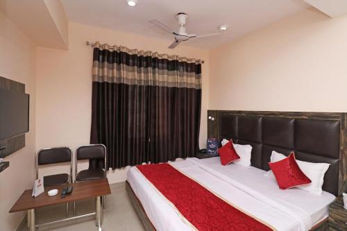 a bedroom with a large bed with red pillows at Hotel O Abc Residency in Srīnagar