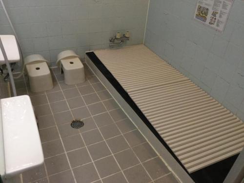 a bathroom with a bed and two toilets at Henmi Ryokan in Hakodate