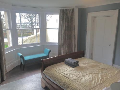 a bedroom with a bed and a chair and a window at Collingwood House Tynemouth in Tynemouth