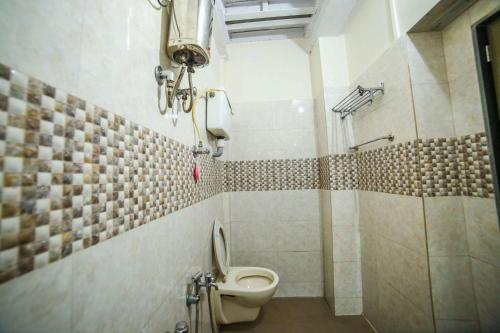 a bathroom with a toilet and a shower at Shri Laxmi Lodge in Mumbai