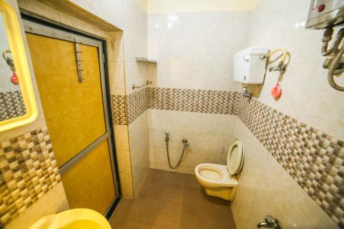 La salle de bains est pourvue d'une douche et de toilettes. dans l'établissement Shri Laxmi Lodge, à Mumbai