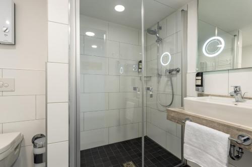 a bathroom with a shower and a sink and a toilet at Trip Inn Hotel & Suites Essen in Essen
