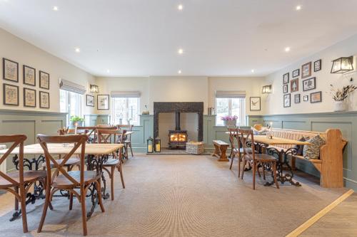 a dining room with tables and chairs and a fireplace at The Old Mill Inn in Dearham
