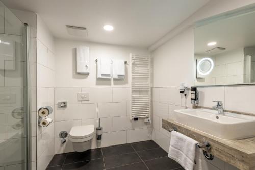 a bathroom with a toilet and a sink and a shower at Trip Inn Hotel & Suites Essen in Essen