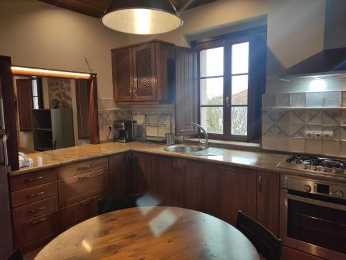 a kitchen with wooden cabinets and a wooden table at O Canto da Terra in Pantón