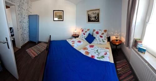 a bedroom with a blue bed in a room at Keller´s Ferienwohnung an der Saale in Schwarzenbach an der Saale