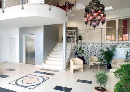 a lobby with stairs and chairs and a chandelier at Gästehaus Catherine in Zierenberg