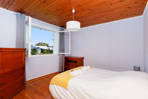 une chambre avec un grand lit blanc et une fenêtre dans l'établissement Villa Carole YourHostHelper., à Roquebrune-sur Argens